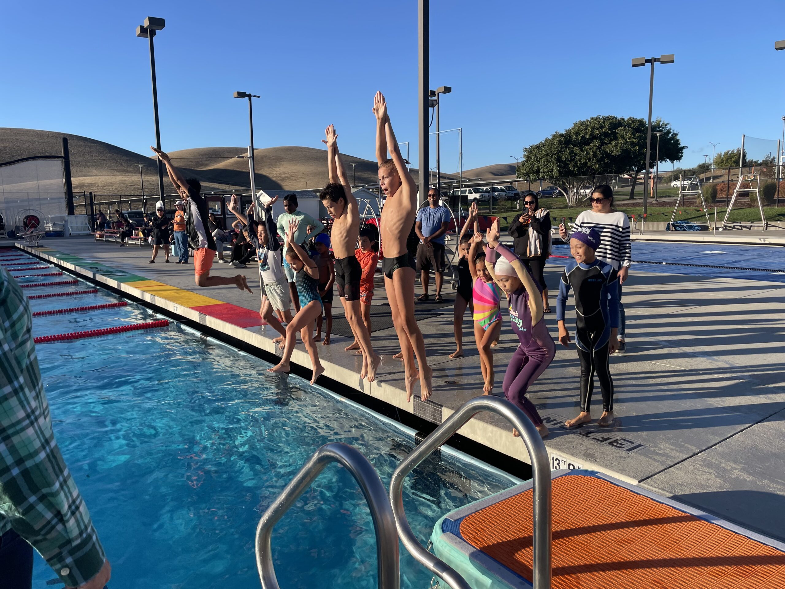 Future Champions divers lined up on deck, arms raised